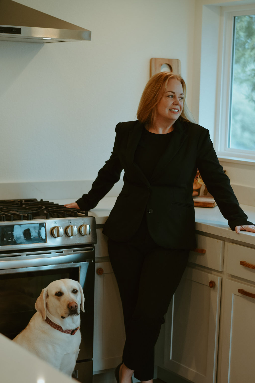 Stacy with her dog Maggie in a kitchen