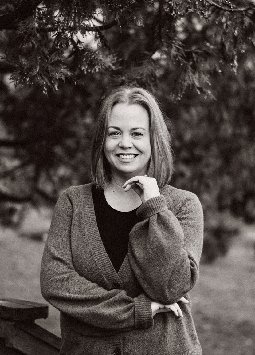 Stacy Coppola smiling outdoors in a black-and-white portrait